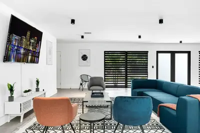 a living room with a blue couch and chairs at Heated Pool Modern 5 Bedrooms House 10 minutes to the Ocean in Miami