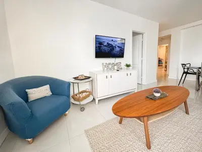 a living room with a blue chair and a table at 2 BEDROOM ON THE BEACH ! in Miami Beach