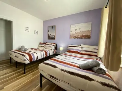 two beds in a room with purple walls at Heart of Miami sleeps 10 near Little Havana Beaches in Miami