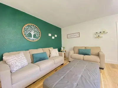 a living room with two couches and a green wall at Lively Home near Downtown, stadium, Wynwood in Miami