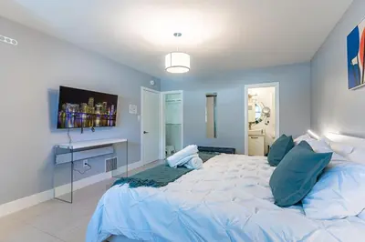 a bedroom with a large bed with blue walls at Villa Aura Heated Pool 4 Bedrooms 5 minutes to the Ocean in Fort Lauderdale