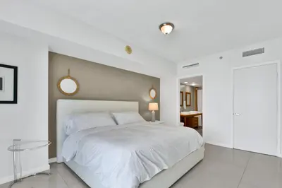 a white bedroom with a large bed and a mirror at Water front Icon Brickell, W Hotel building in Miami