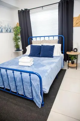 a bed with a blue frame in a bedroom at Insta Worthy Oasis in Homestead