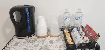 a table with bottles of water and a coffee pot at Insta Worthy Oasis in Homestead