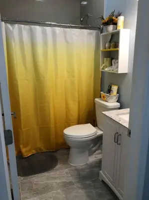 a bathroom with a toilet and a yellow shower curtain at NEW Luxurious Studio Private in the heart of Miami in Miami
