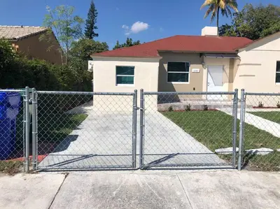 a chain link fence in front of a house at NEW Luxurious Studio Private in the heart of Miami in Miami