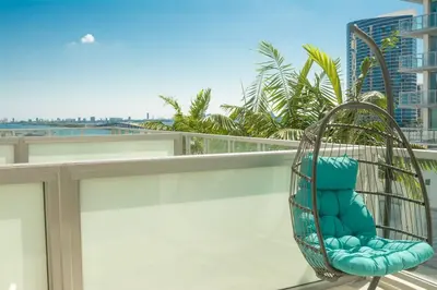 a rattan chair on the balcony of a building at Luxury Oceanview Studio at Miami Design District in Miami