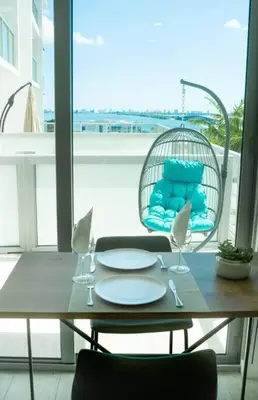 a table and chairs with a table and a chair with a balcony at Luxury Oceanview Studio at Miami Design District in Miami