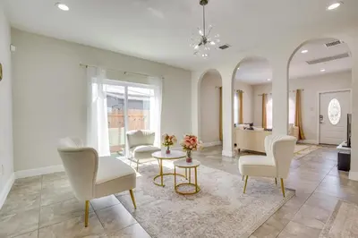 a living room with white chairs and a table at Stylish Fort Lauderdale Home 5 Mi to Beach! in Fort Lauderdale