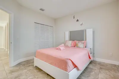 a white bedroom with a pink bed with pink sheets at Stylish Fort Lauderdale Home 5 Mi to Beach! in Fort Lauderdale