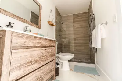 a bathroom with a wooden sliding shower door and a toilet at Amazing Villa at Highland Lakes Boulevard BY THE GLAMHOMES in Miami