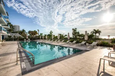 a swimming pool with chaise lounge chairs next to a building at Churchill Suites Monte Carlo Miami Beach in Miami Beach