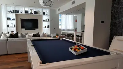 a living room with a pool table with a bowl of fruit at Churchill Suites Monte Carlo Miami Beach in Miami Beach