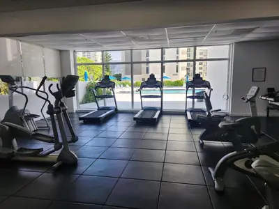 a gym with treadmills and elliptical machines at Entire Beach Front Condo w/ pool Amazing view 4pax in Miami Beach