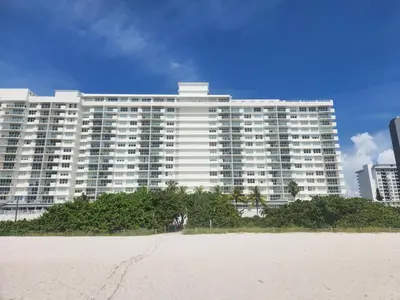 a large white building with a beach in front of it at Entire Beach Front Condo w/ pool Amazing view 4pax in Miami Beach