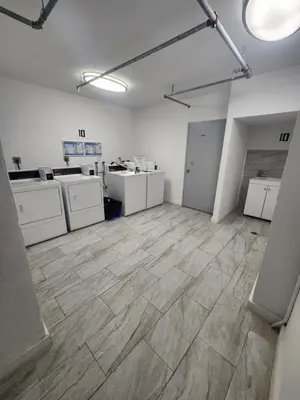 a large room with wooden floors and white appliances at Entire Beach Front Condo w/ pool Amazing view 4pax in Miami Beach