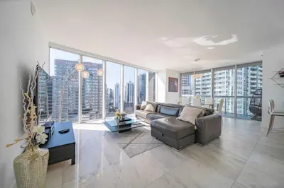a living room with a couch and a large window at Luxury Ocean View 2BR Corner Unit at W residence in Miami