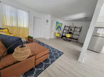a living room with a brown couch and a kitchen at Sol Miami # 2 with free parking in Miami