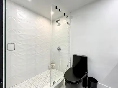 a bathroom with a shower with a black toilet at Oceanfront 3 Room Ocean Drive Condo in Miami Beach