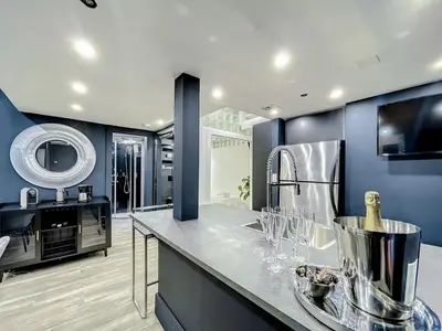 a kitchen with blue walls and a counter with wine glasses at Oceanfront 3 Room Ocean Drive Condo in Miami Beach