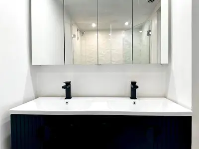 a bathroom with a white sink and a mirror at Oceanfront 3 Room Ocean Drive Condo in Miami Beach