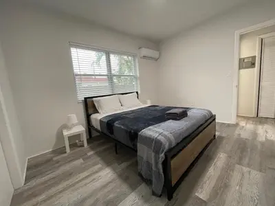 a bedroom with a bed and a large window at Douglas rd apartments in Miami
