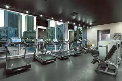 a gym with several cardio machines and a city skyline at Trendy Beachfront Flat, Sea Views, Style & Amenities -A in Hallandale Beach