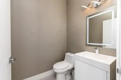 a bathroom with a white toilet and a sink at Super Modern Waterfront Paradise Near the Beach in Miami