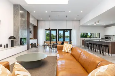 a living room with a brown couch and a kitchen at Super Modern Waterfront Paradise Near the Beach in Miami