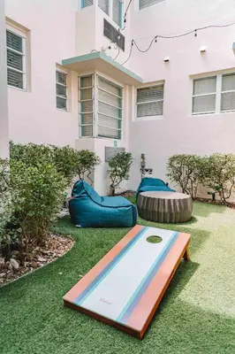 a pool in the grass in front of a building at Beds n' Drinks in Miami Beach