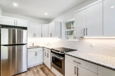 a kitchen with white cabinets and a stainless steel refrigerator at Beautiful Shenandoah One Bedroom Fast Internet Shen3 in Miami
