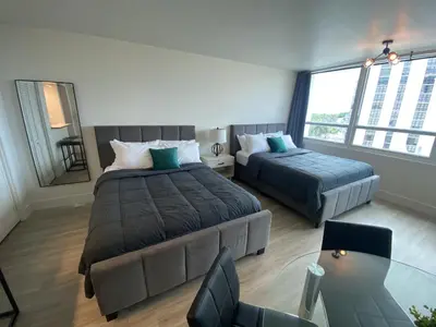 a large bedroom with two beds and a glass table at Studio Miami Beach sobre la playa in Miami Beach
