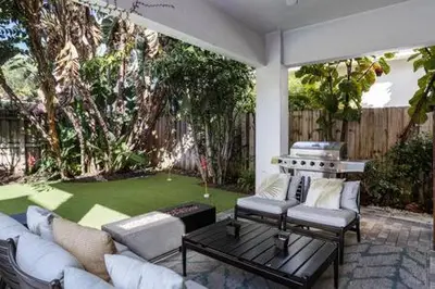 a patio with couches and a putting green at VILLA MAGNOLIA-with heated pool-by VIAC in Fort Lauderdale