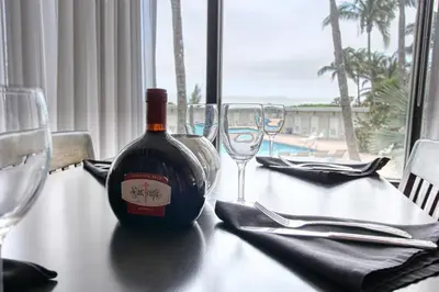a bottle of wine sitting on a table with glasses at Deluxe Studios and Apartments at the Casablanca in Miami Beach