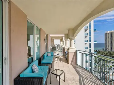 a balcony with blue chairs and a view of the ocean at King David By The Ocean in Miami Beach