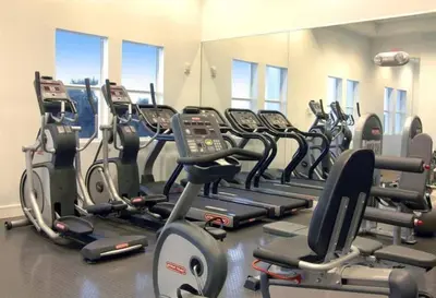 a gym with a row of treadmills and machines at Villa Vista-2 Story w 3Bdrms & Golf View in Miami