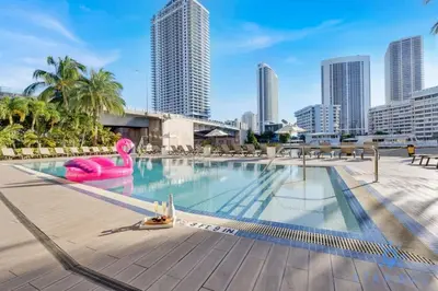 a large swimming pool with a city skyline in the background at Infinity View - Balcony - Pool - Gym - Near Beach in Hallandale Beach