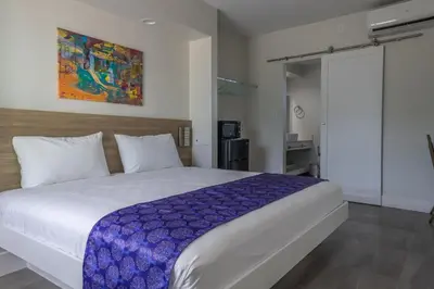 a bedroom with a large bed with a blue blanket at The Biscayne Hotel in Miami