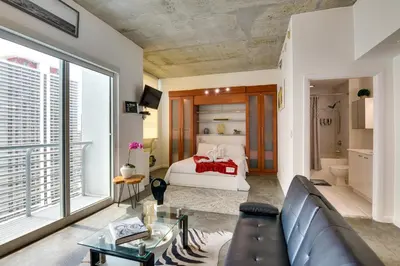 a living room with a couch and a bed at Trendy Downtown Miami Studio Pools, Views and More! in Miami