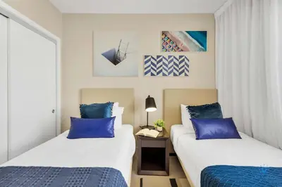 two beds in a hotel room with blue pillows at Awesome Bayview - Pools - Gym in Hollywood