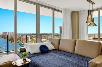 a living room with a couch and large windows at Awesome Bayview - Pools - Gym in Hollywood