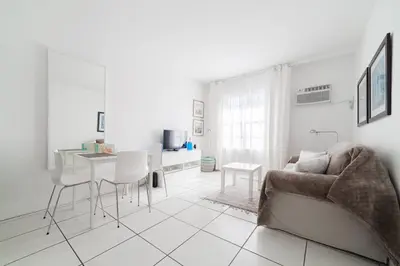 a white living room with a couch and a table at BEACH VIBES in Miami Beach
