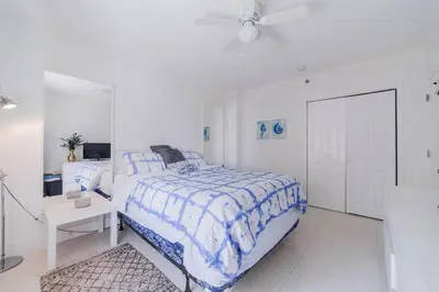 a white bedroom with a bed and a white cabinet at OCEAN & SAND ONLY 1 MINUTE WALK! in Miami Beach
