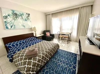 a hotel room with a bed and a chair and a table at APARTMENT RIGHT ON THE BEACH! in Miami Beach