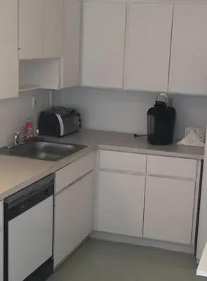 a kitchen with white cabinets and a sink at APARTMENT RIGHT ON THE BEACH! in Miami Beach