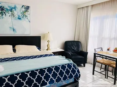 a bedroom with a bed and a chair and a desk at APARTMENT RIGHT ON THE BEACH! in Miami Beach