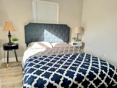 a bedroom with a bed with a blue and white comforter at HOT TUB HOUSE ON GOLF COURSE! 10 MINs TO THE BEACH in Miami
