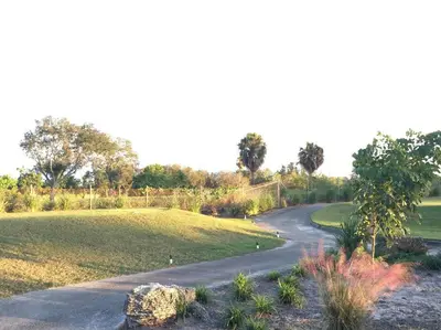 a winding road through a park with a field at HOUSE WITH POOL, 10 MINS DRIVE TO THE BEACH! in Miami Shores