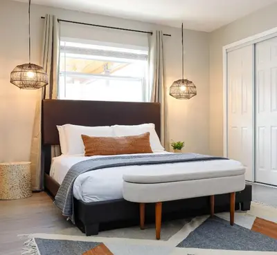 a bedroom with a large bed with two pendant lights at La Vie Boheme 2 - Charming Oasis w Parking in Miami
