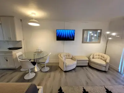 a living room with a table and chairs and a tv at Estudios para 4 personas en la playa de Sunny Isles Beach in Miami Beach